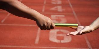 Läufer übergeben den Relaystab auf einer Rennstrecke