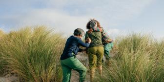 Ältere Freundinnen gehen zusammen am Strand spatzieren